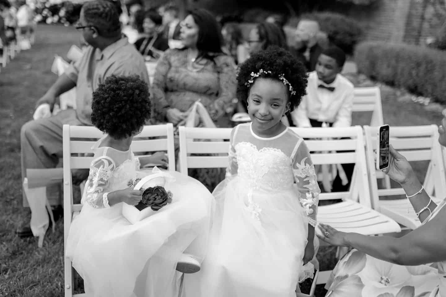 Candid moment of flower girl smiling at Detroit wedding ceremony. Photographed by Michigan Wedding Photographer.