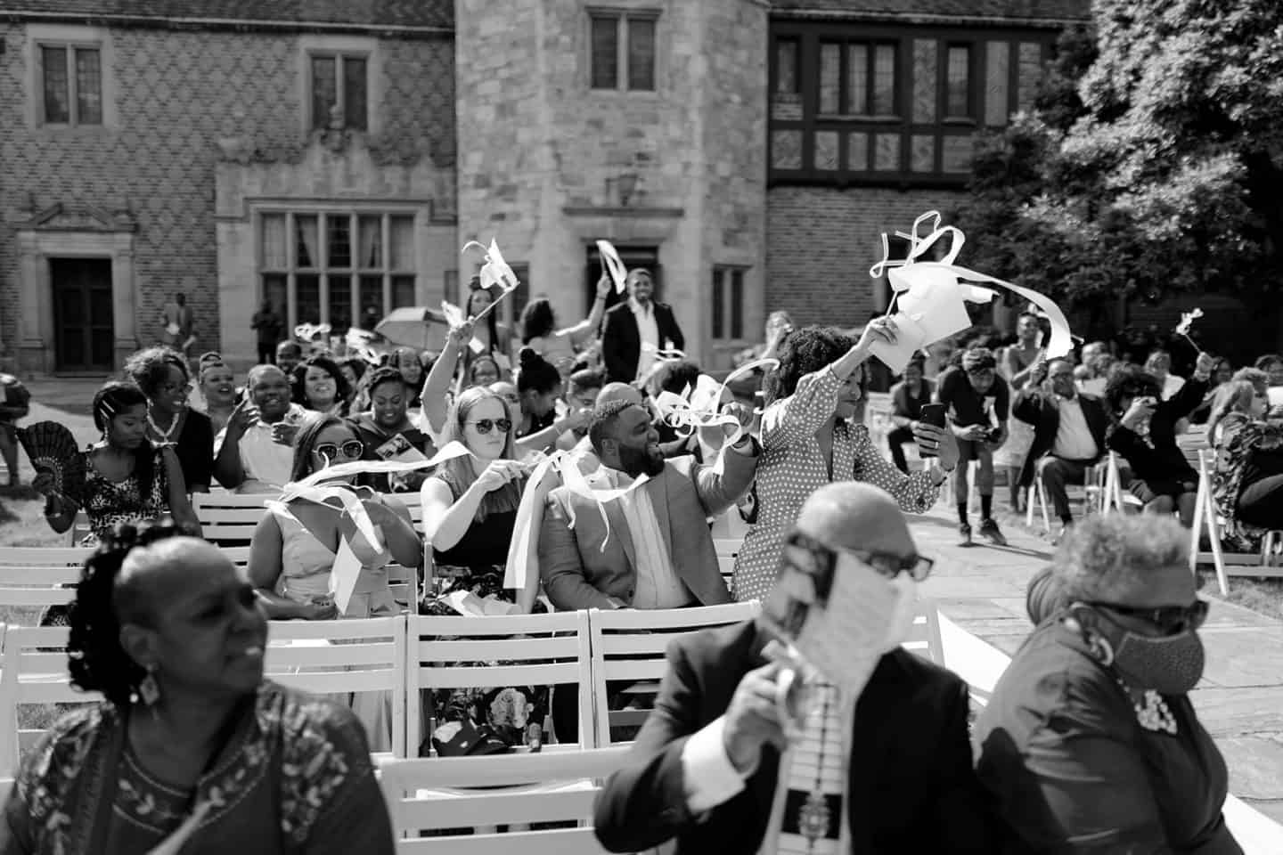 Wedding guests cheering at outdoor wedding in Detroit, Michigan.